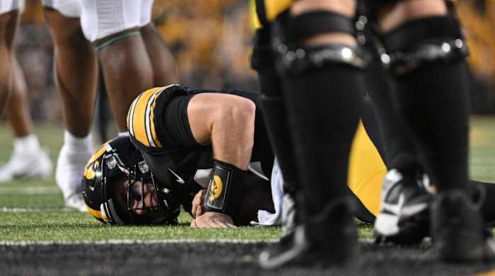 Iowa quarterback Cade McNamara lies on the ground after suffering a leg injury